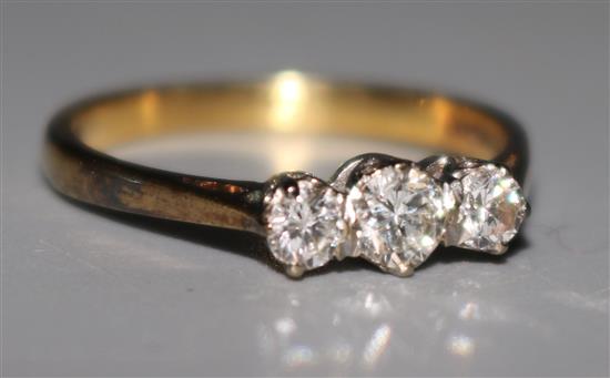 An 18ct gold and three stone diamond ring, size M.